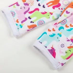 Manche rétractable de vêtement bébé décorée de licornes multicolores, cœurs et fleurs sur fond blanc.