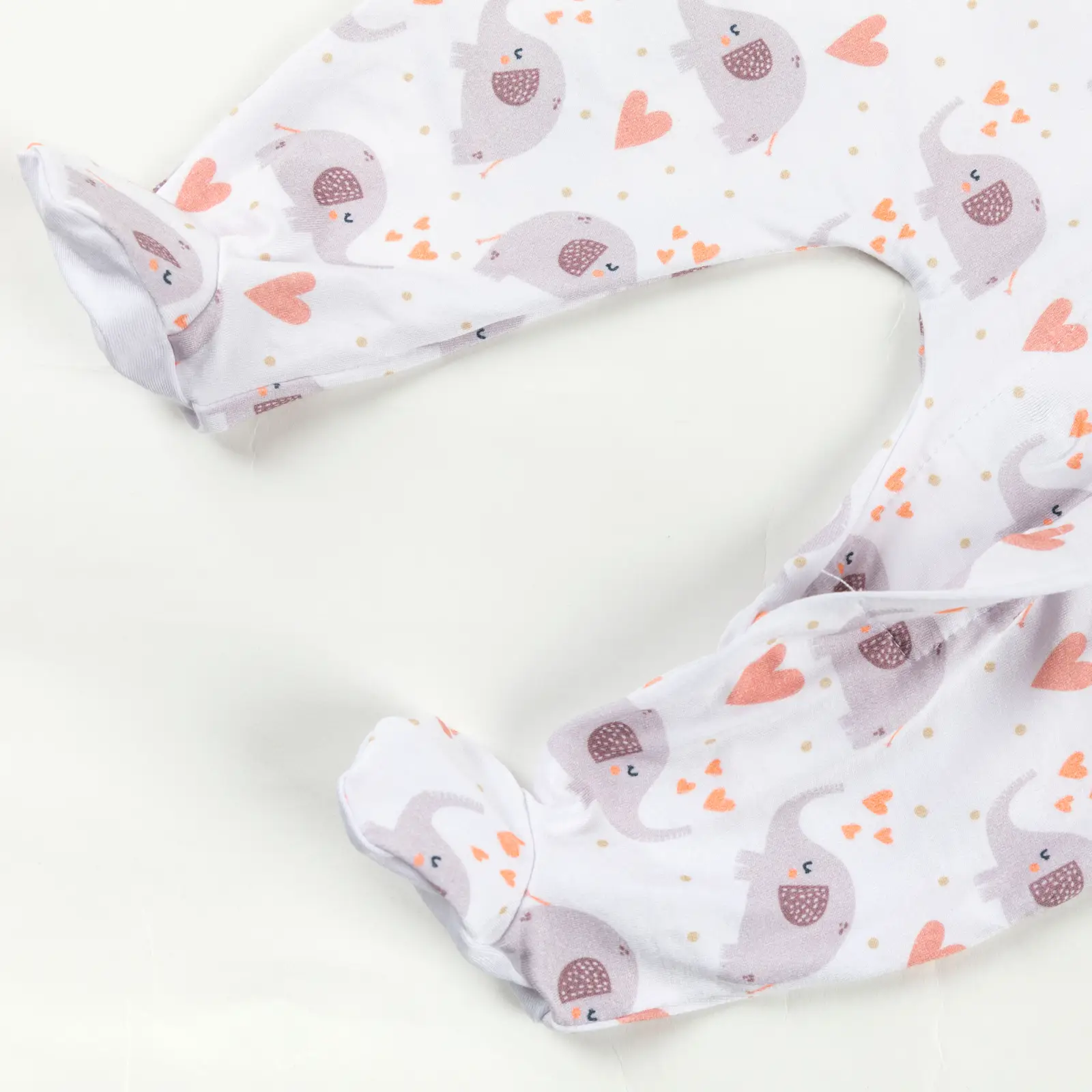 Bas de pyjama bébé décoré d’éléphants gris et de cœurs orange sur fond blanc.