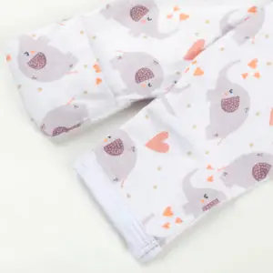 Manche rétractable de pyjama bébé décorée d’éléphants violets et de cœurs orange sur fond blanc.