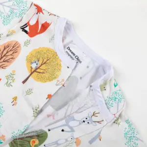 Haut de pyjama bébé décoré d’animaux de la forêt et d’arbres colorés sur fond blanc.