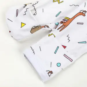 Manche rétractable de pyjama bébé décorée de lamas colorés et formes géométriques sur fond blanc.