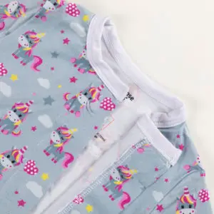 Haut de pyjama bébé bleu décoré de licornes colorées, étoiles et nuages.