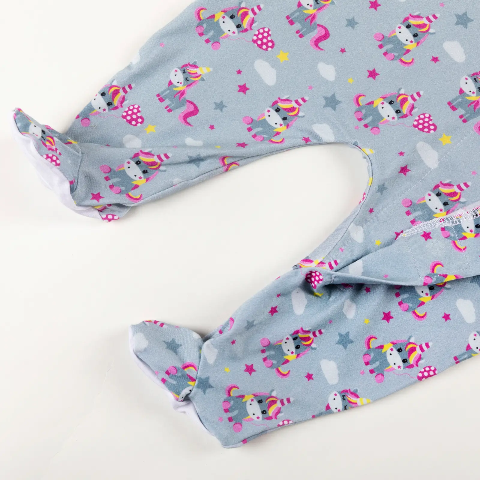 Bas de pyjama bébé bleu décoré de licornes colorées, étoiles et nuages.