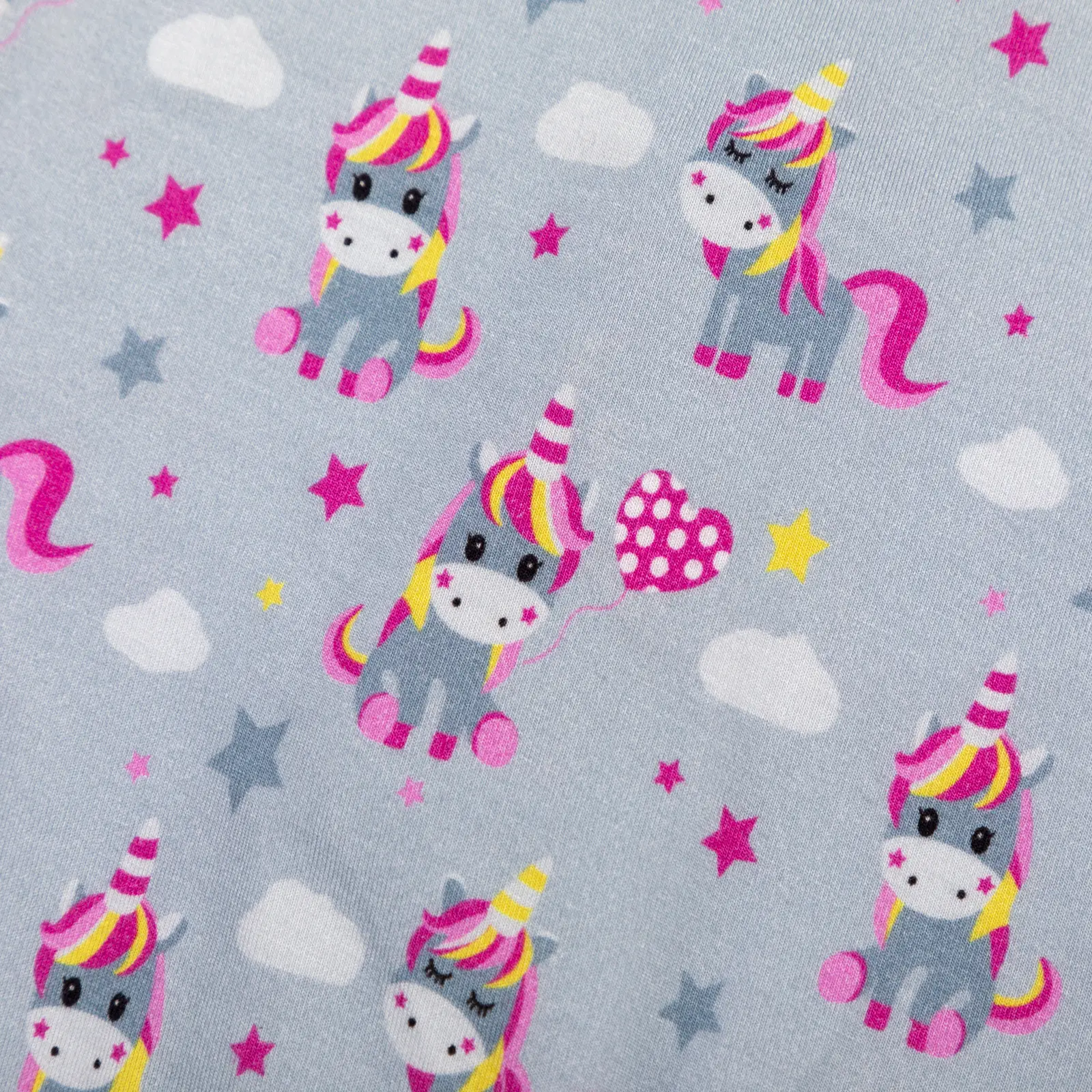 Motif enfantin de licornes colorées avec étoiles, nuages et ballons sur fond bleu clair.