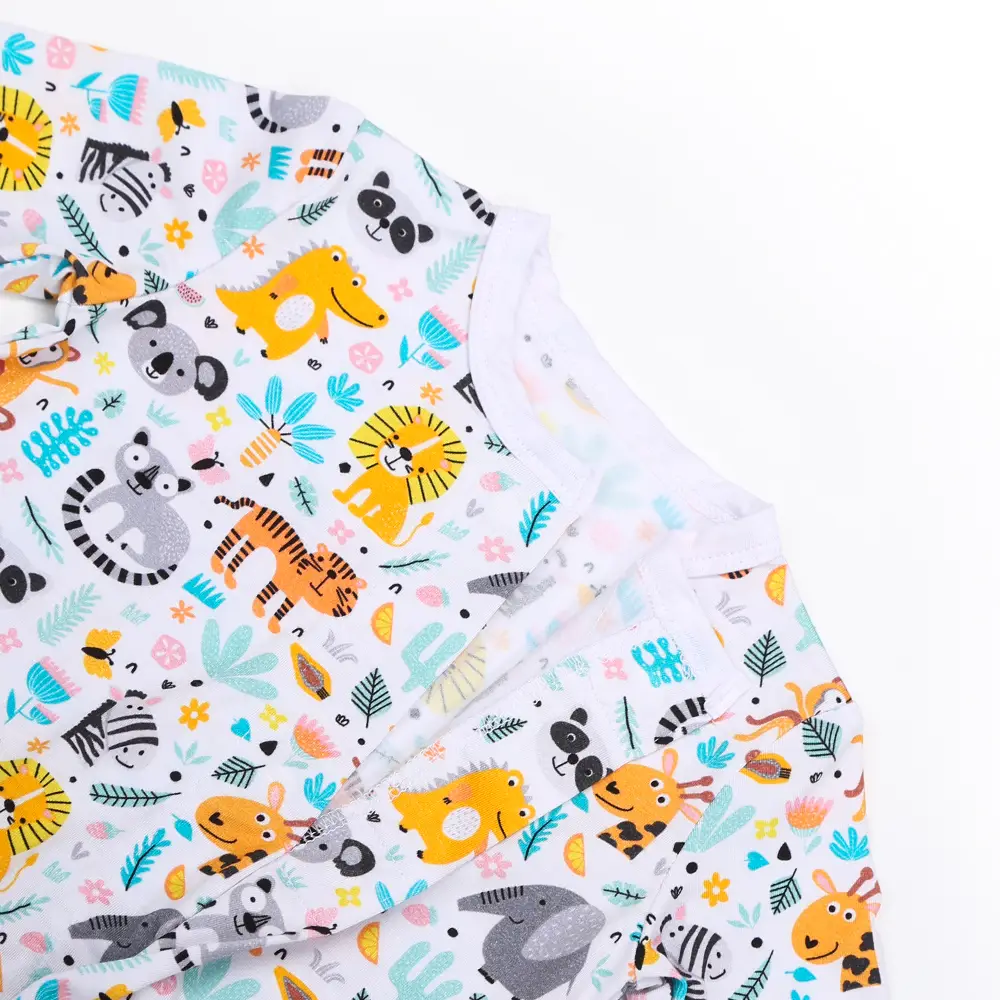 Vêtement pour enfant en tissu blanc décoré de dessins colorés d’animaux comme lions, tigres, éléphants, girafes, zèbres, koalas, pandas et hippopotames, avec des éléments floraux et feuillages.