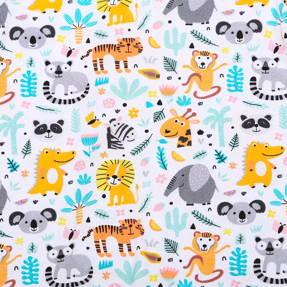 Pyjama blanc à pieds pour bébé avec fermeture magnétique et motifs de petits lions et arcs-en-ciel.