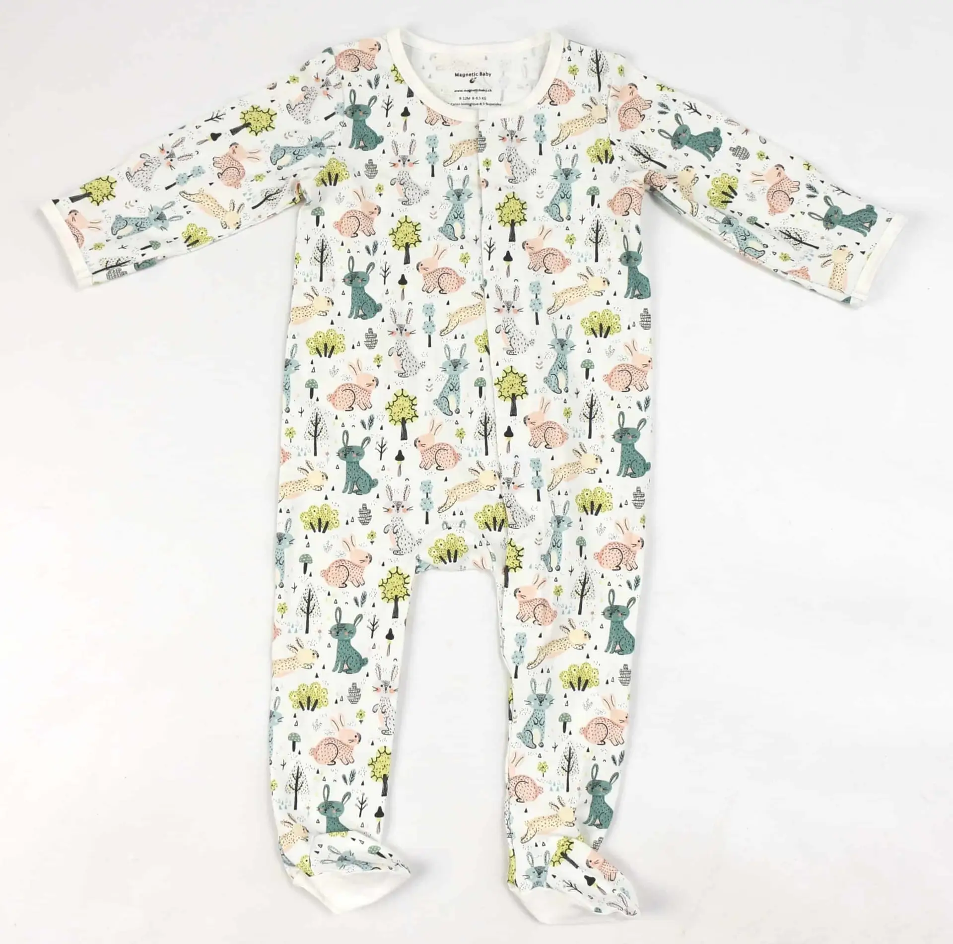 Pyjama blanc à pieds pour bébé avec motifs de lapins et fermeture magnétique.